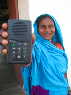 Woman smiling holding up MegaVoice audio Bible