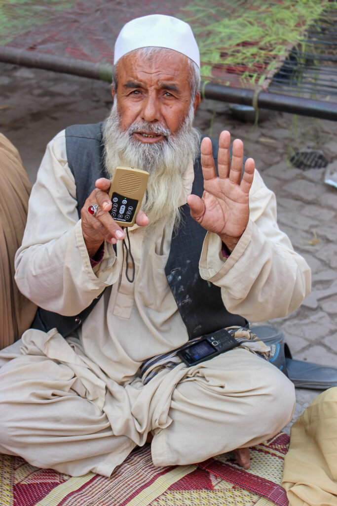WM Afghan Audio Bible Distribution Afghan Elder holding up MegaVoice player